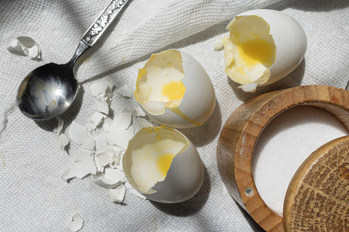 Empty eggshells and opened saltcellar left after cooking breakfast.
