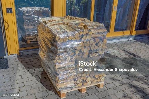 istock Close up view of birch firewood in transport nets wrapped in plastic film. Sweden. 1421095651