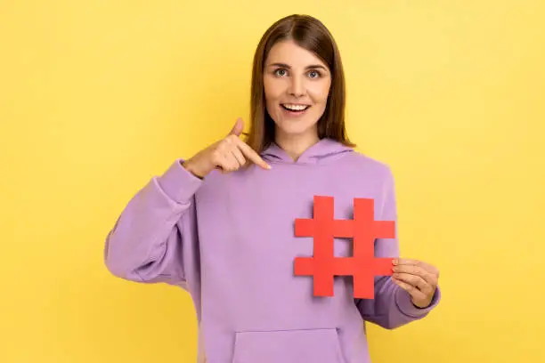 Photo of Happy woman pointing at red hashtag symbol making important topic popular setting trends on Internet