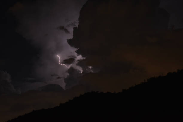 istock Lightning bolt strike in dark moody clouds 1421099806