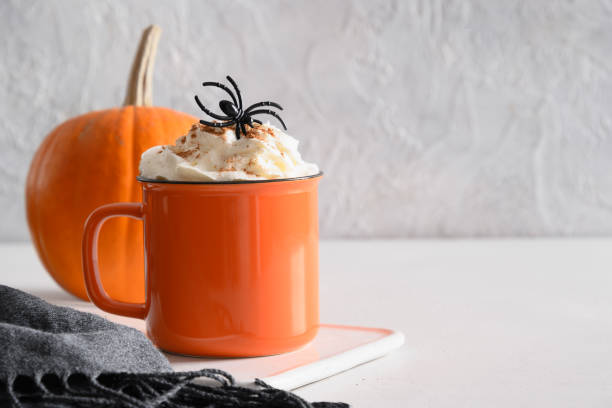 Halloween pumpkin latte coffee with whipped cream decorated spiders Halloween pumpkin latte coffee with whipped cream decorated spiders on white background. Horror funny food. Copy space. Close up. gross coffee stock pictures, royalty-free photos & images