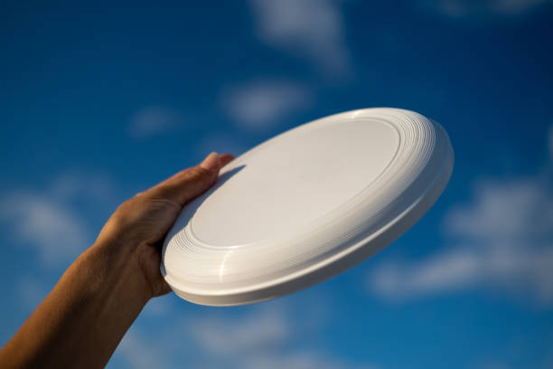istock Female hand holding white frisbee. 1421100953