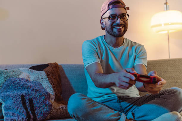 istock Young man playing video games at home 1421101970