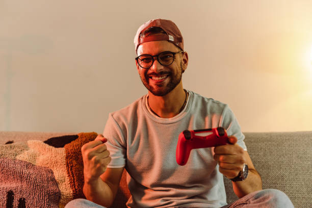 istock Young man playing video games at home and cheering 1421102168