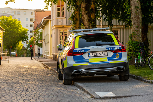 Alingsås, Sweden - June 11 2022: Volvo policecar parked on a sidewalk in evening light.