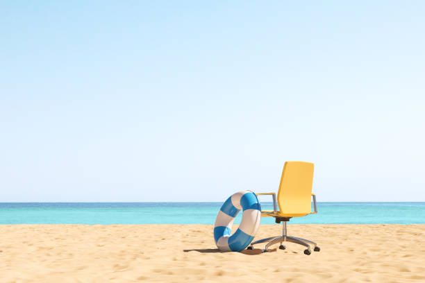 Office armchair and rubber ring on a beach, vacation. Copy space stock photo