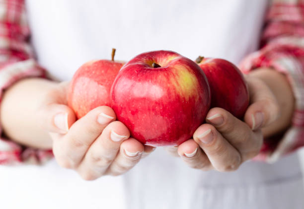 Young woman holding red apples.