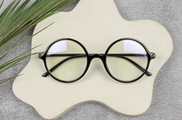 istock Stylish round glasses for vision on a beige podium, close-up 1421107962