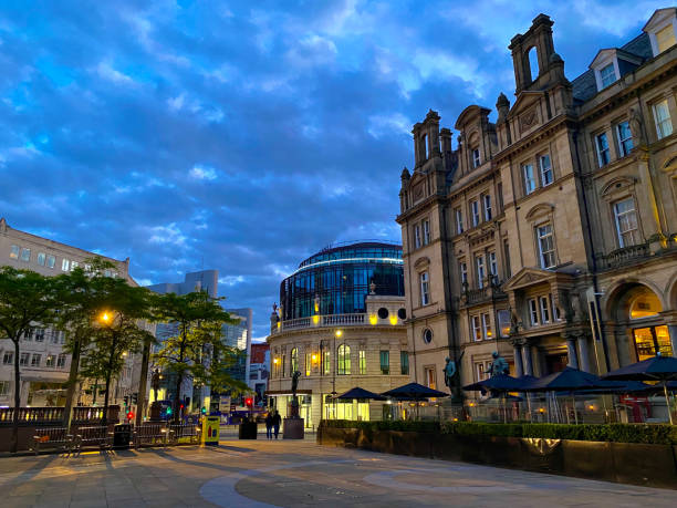 Leeds City Square at night. This is a large public square in the centre of the city. The main building shown is a former post office, now converted into several bars, restaurants and offices. Other offices and hotels surround the square.