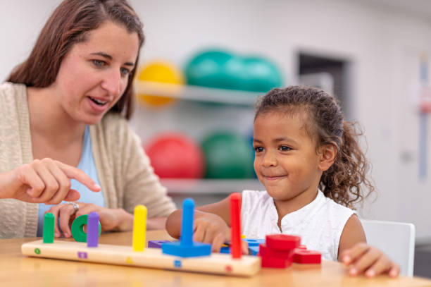 istock Ethnic pre-schooler working with her teacher in a classroom 1421112248