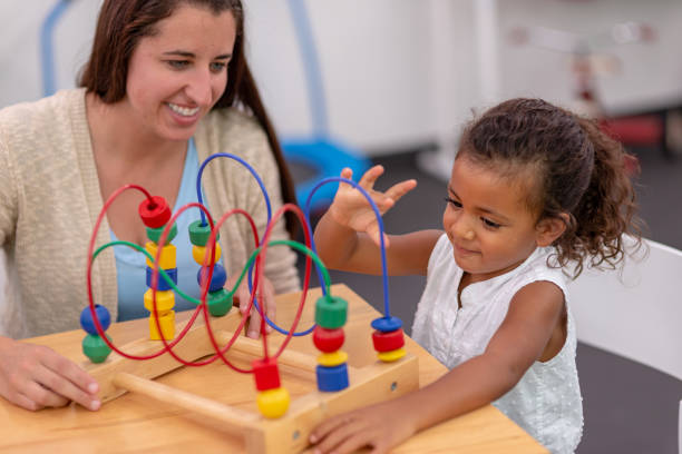 istock Ethnic pre-schooler working with her teacher in a classroom 1421112249