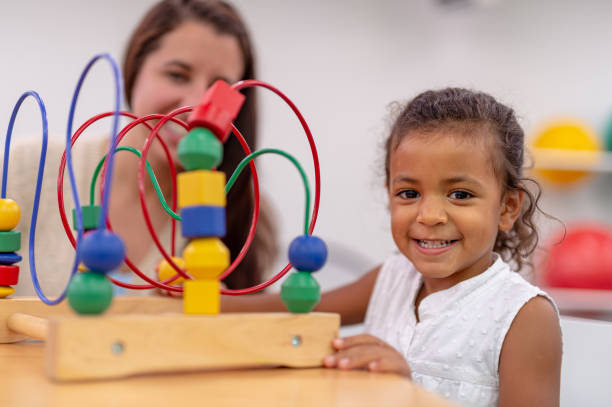 istock Ethnic pre-schooler working with her teacher in a classroom 1421112259