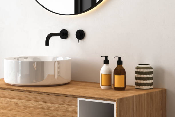 istock Close up of sink with oval mirror standing in on white wall 1421113229