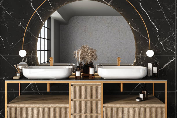 istock Close up of double sink with oval mirror hanging on black marble wall 1421114314