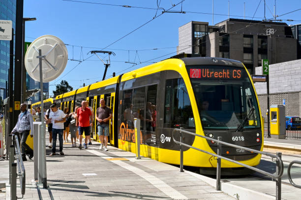 people getting off a modern electric tram in utrecht city centre - utrecht stockfoto's en -beelden