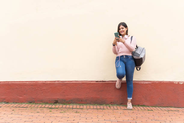 istock girl typing on cell phone in yellow 1421116621