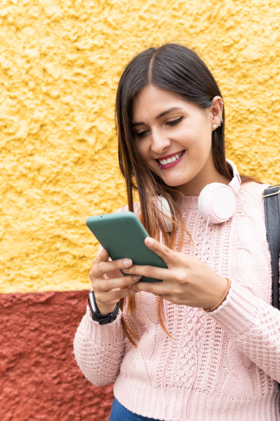 istock girl smiling typing on the cell phone 1421116631