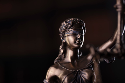 Law symbols composition. Themis sculpture and judge’s gavel on gray background.