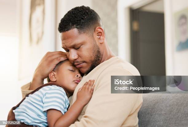 Sleeping And Tired Child With Caring Father Holding His Sleepy Son On A Home Lounge Sofa Worried Dad Hugging His Young Boy Resting On A Living Room Family Couch Indoors Feeling Stress And Worry Stock Photo - Download Image Now