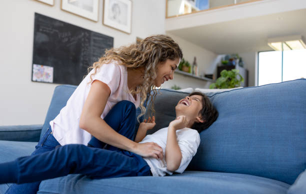istock Playful mother tickling her son while having fun at home 1421125381
