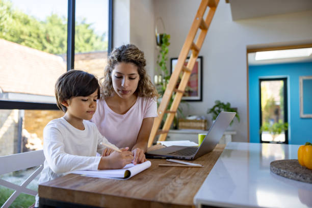 istock Mother helping her son do his homework 1421125505