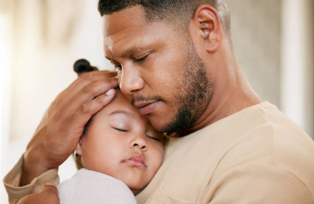 istock Father carrying his sleeping daughter, hugging and bonding with affection at home. Caring parent enjoying fatherhood, holding his girl child, enjoying quiet moment of care, consoling and safety 1421125720