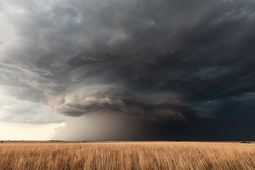 A dramatic supercell storm with dark, ominous clouds over a wheat field near Greensburg, Kansas, USA.