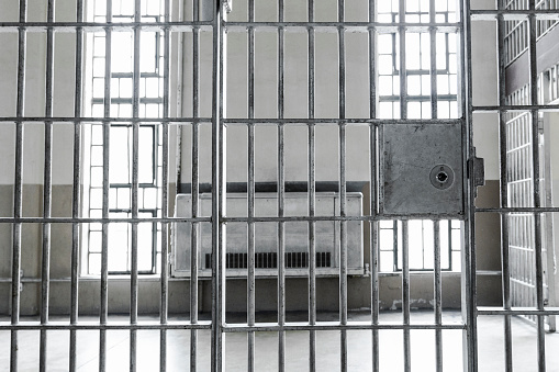 Close up of a mature businessman in a prison cell or in a psychiatric hospital with a mental illness