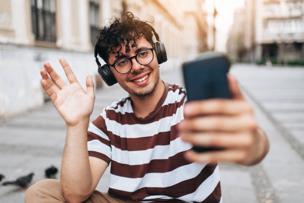 istock Cheerful young man using smart phone in a city 1421132382