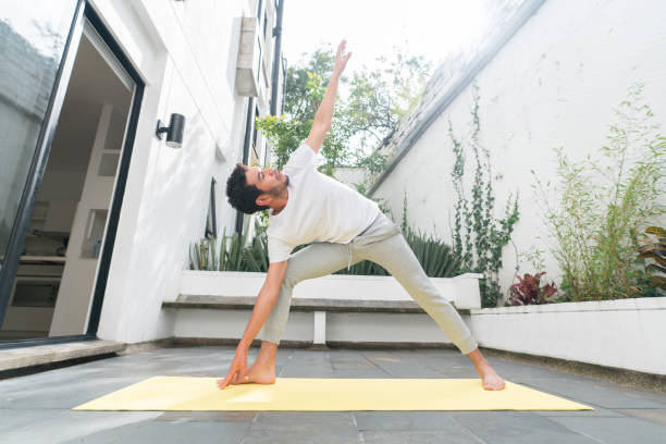 istock Man at home doing stretching exercises in the morning 1421136818