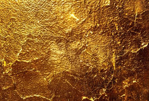 Gold texture. Golden Ore rocks. Rock texture. Stone background. Abstract texture. Shimmering surface. Precious Foil. Rough structure mineral.