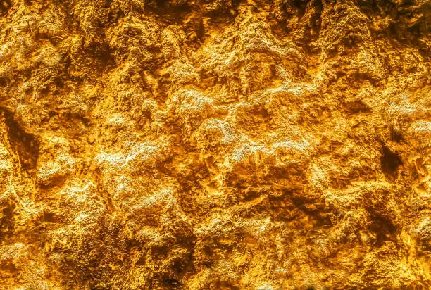 Photo of Gold texture. Golden Ore rocks. Rock texture. Stone background. Abstract texture. Shimmering surface. Precious Foil. Rough structure mineral.