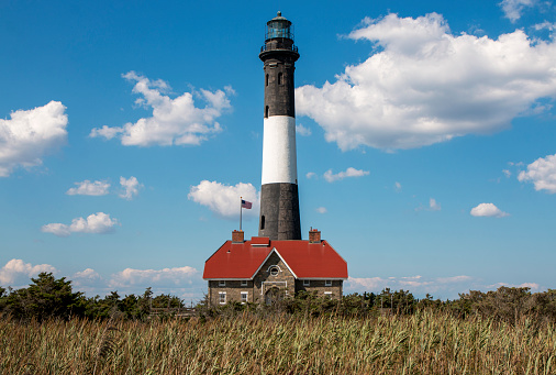 The Fire Island Lighthouse with very dry beach grass and brush in the foreground due to server drought conditions during the summer of 2022.