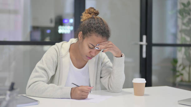 istock African Woman having Disappointment while Writing on Pape 1421148016