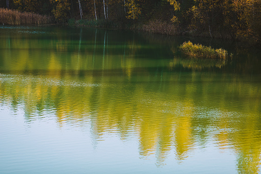 Autumn colors reflected in the lake at sunset creating impressionistic shapes in the water