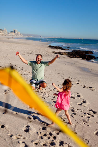 아버지는 딸에게 해변에서 연을 가지고 놀도록 가르치십시오. - wyoming family mountain vacations 뉴스 사진 이미지