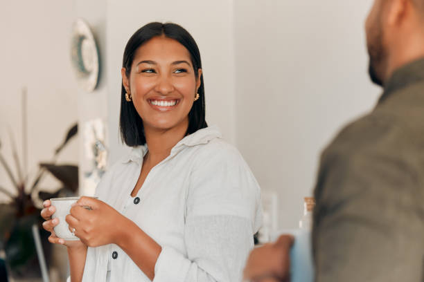 woman drinking coffee, having conversation and bonding with her husband at home. smiling, happy and relaxed wife enjoying quality time, romantic and peaceful moment as a couple in loving relationship - life events laughing women latin american and hispanic ethnicity imagens e fotografias de stock