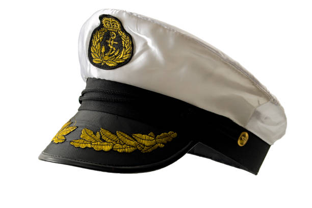 Maritime authority, naval command staff and officer uniform concept with formal ship captain cap and badge isolated on white background with clipping path cutout Maritime authority, naval command staff and officer uniform concept with formal ship captain cap and badge isolated on white background with clipping path cutout sailor hat stock pictures, royalty-free photos & images