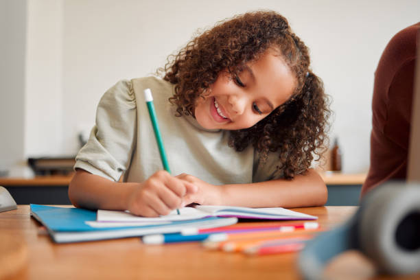 istock Learning, smiling and creative young girl drawing with a colorful pencil feeling happy and content. Positive student with a smile having a fun time creating artistic art in her kids notebook at home 1421158534