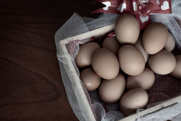 istock Chicken eggs basket on wooden background 1421165420