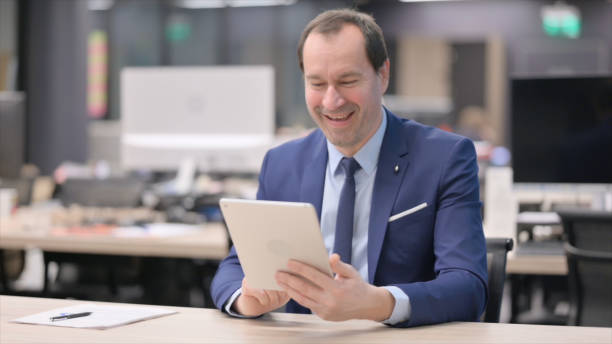 istock Businessman making Video Call on Tablet in Office 1421175495