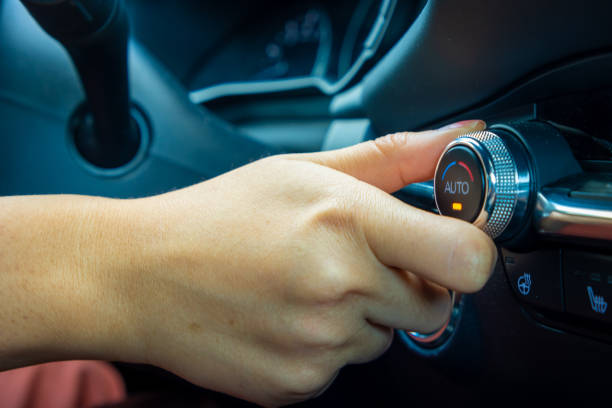 istock Woman adjusts temperature knob inside car 1421183442
