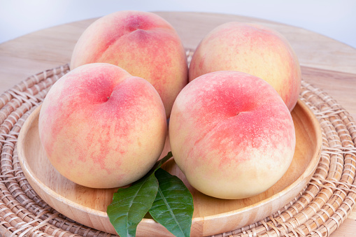 Fresh healthy peaches on a peach tree closeup view