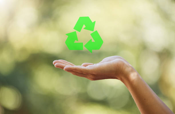 istock Hand, closeup recycle sign isolated with bokeh effect background. Zero waste, ecology and environmental symbol  for sustainable living. Clean and eco friendly habits to protect and save the earth. 1421185745