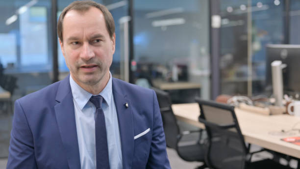 istock Senior Businessman Talking to Colleague at Work 1421189653