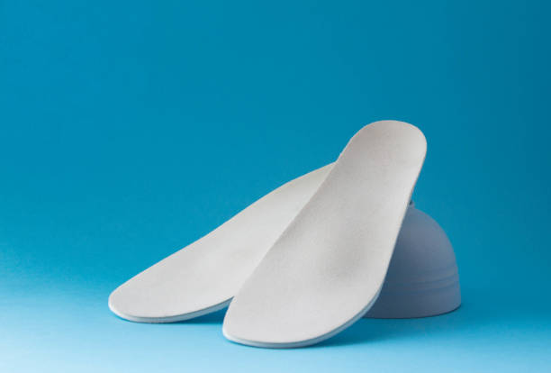 istock Leather orthopedic insoles on blue background. Prevention and tr 1421190101