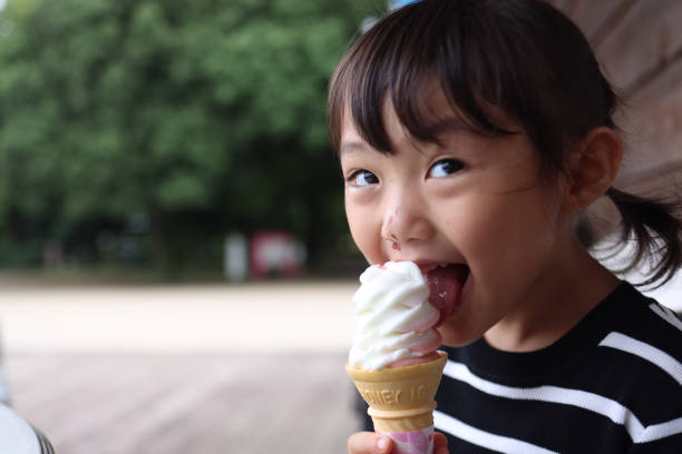istock Daughter eating  icecream at cafe  in park 1421194148