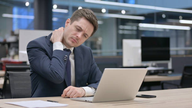 istock Businessman having Neck Pain while using Laptop in Office 1421194271