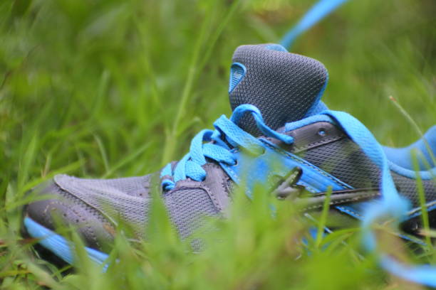 istock close up of a man putting a shoelace sitting on the green grass, Central Java, Indonesia 1421194664