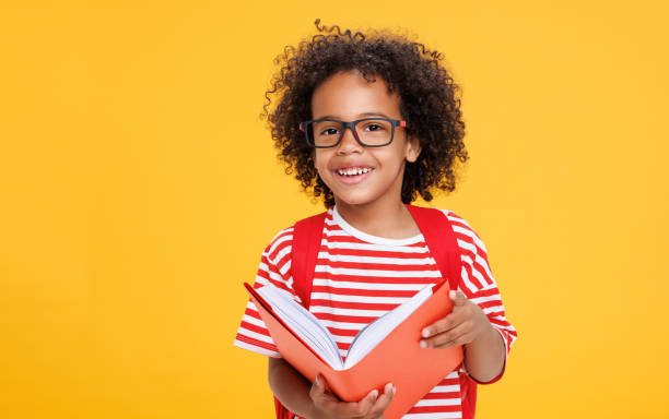 istock Happy ethnic schoolboy laughing with book 1421194890